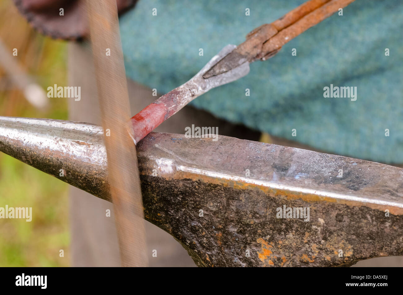 Ein Schmied verwendet eine Datei, ein Stück glühendes Eisen zu gestalten Stockfoto