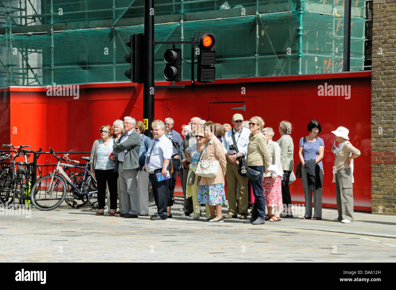 Gruppe von Menschen, Touristen warten auf die Straße zu überqueren, Kings Cross, London England Großbritannien Stockfoto