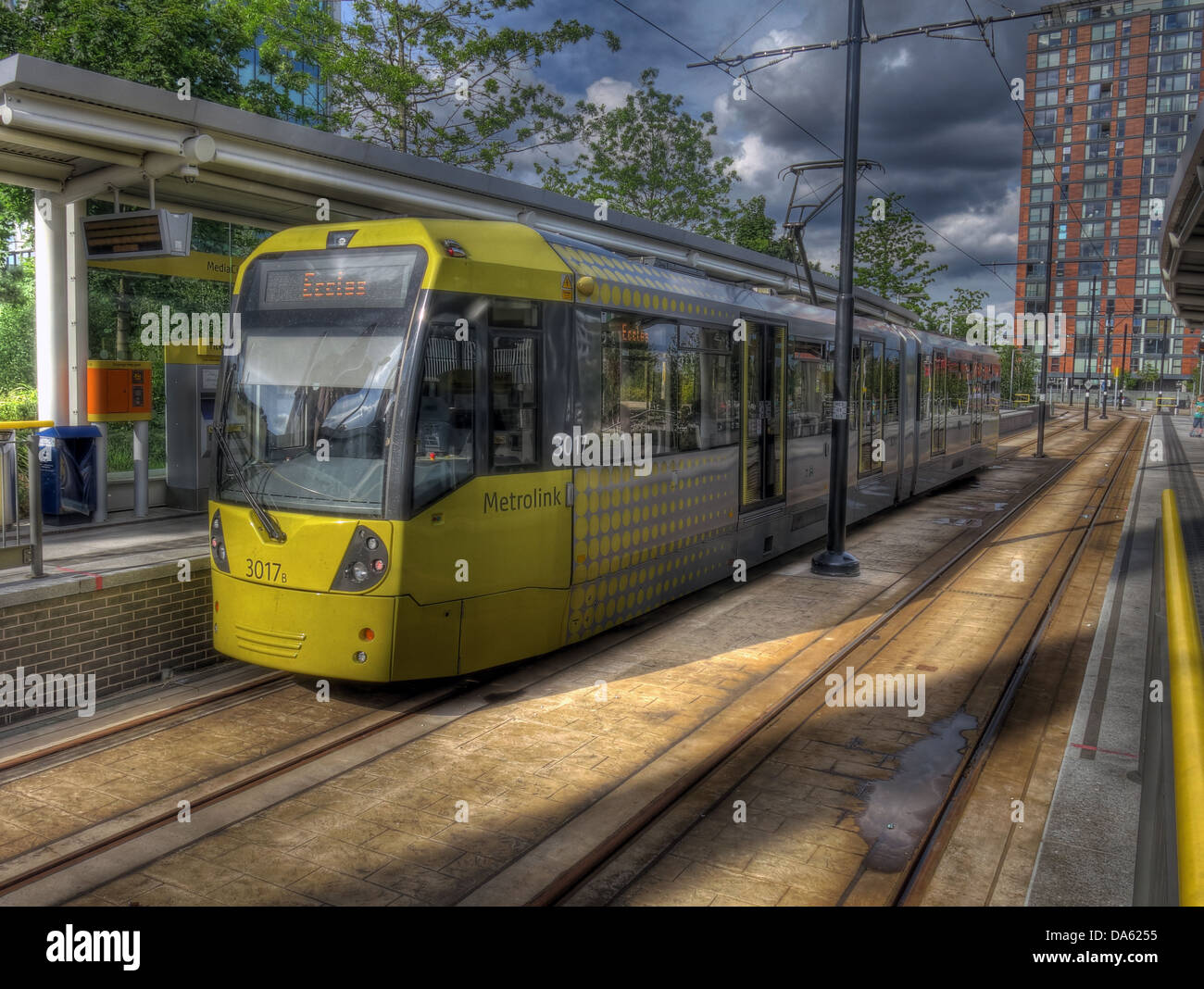 Gelben Straßenbahn an der Medienstadt Metrolink Station, Salford Quays, Manchester, England UK Stockfoto