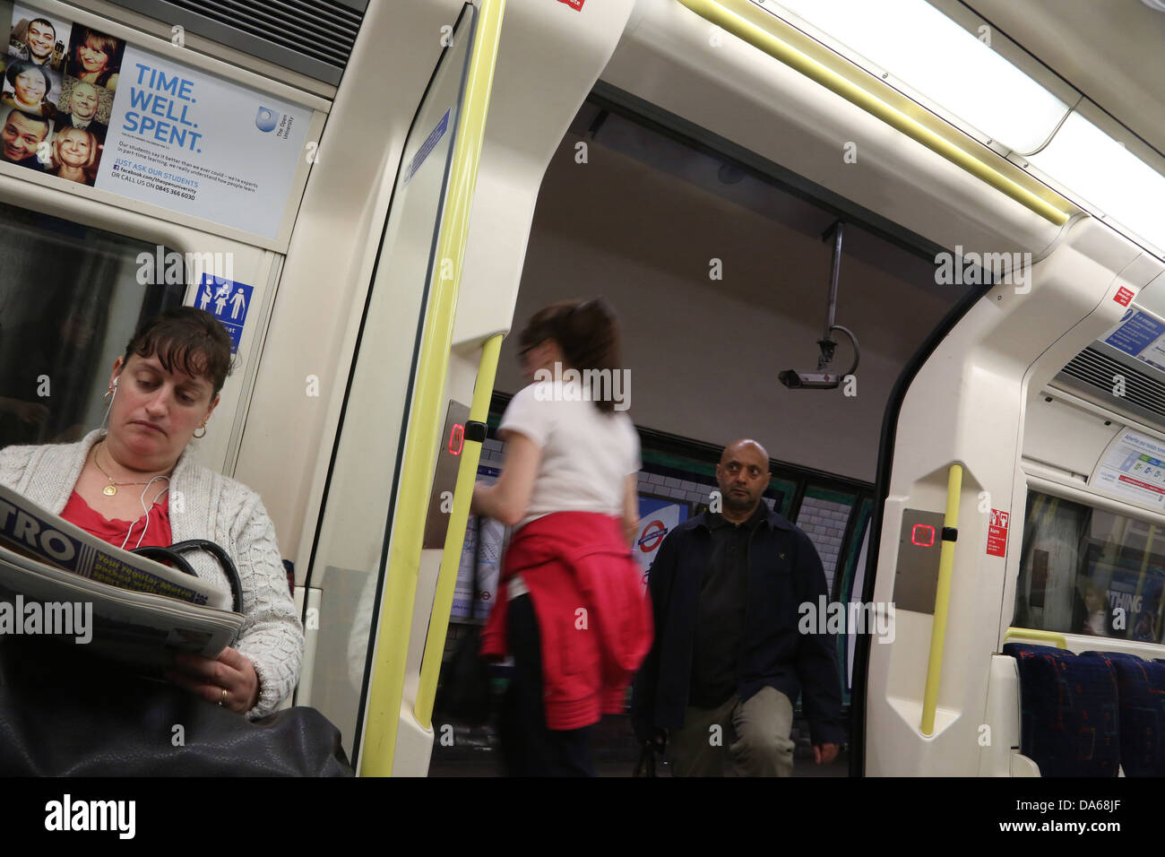 London England Priorität Sitz Menschen einsteigen in das Rohr und Aussteigen auf der Northern Line Frau Metro Zeitung lesen Stockfoto