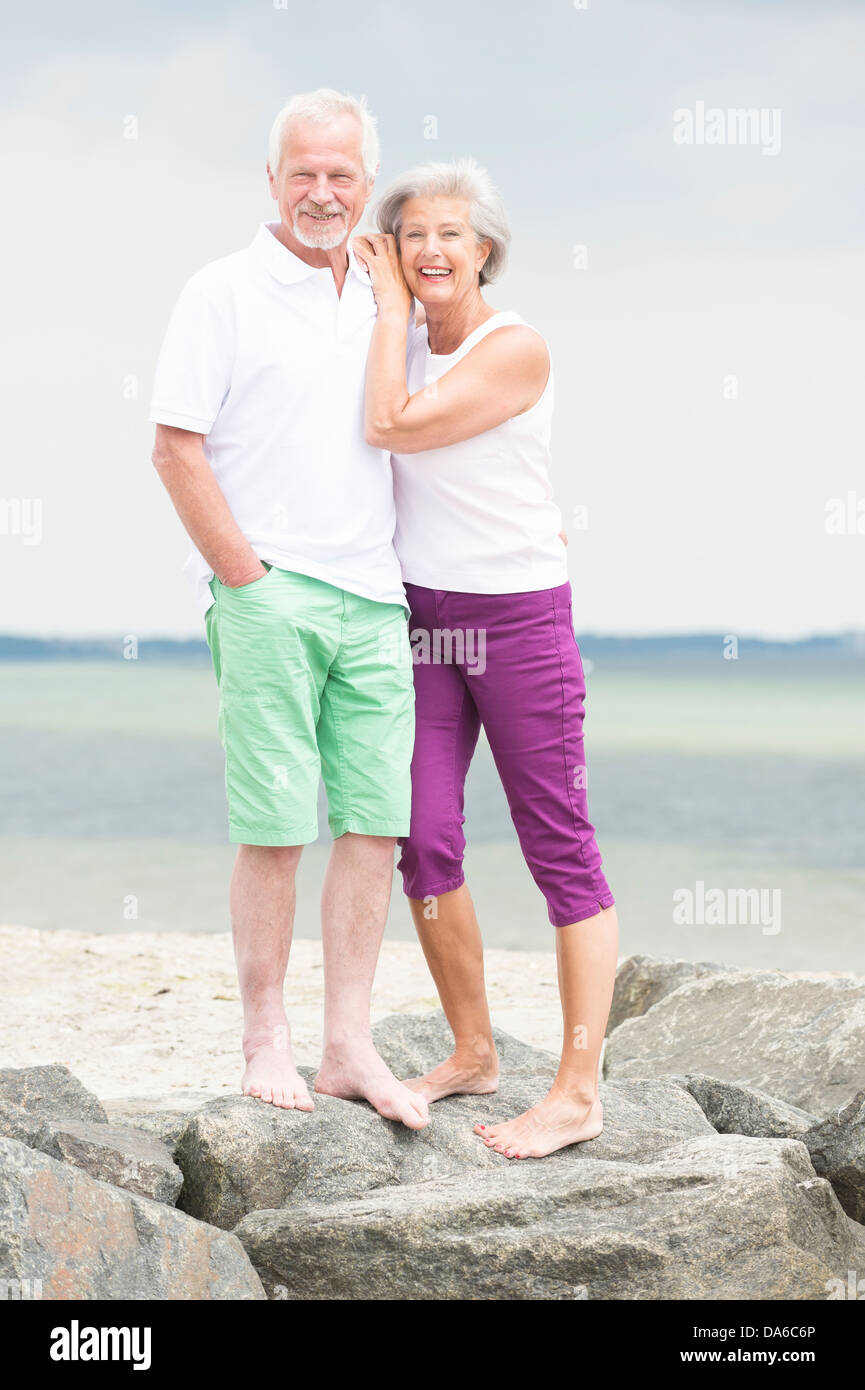 Glücklich und lächelnd älteres Paar am Strand Stockfoto