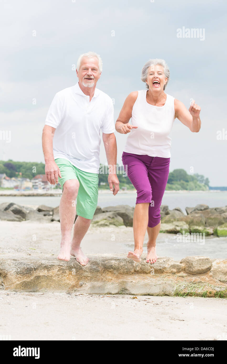 Aktiv und sportlich älteres Paar am Strand Stockfoto