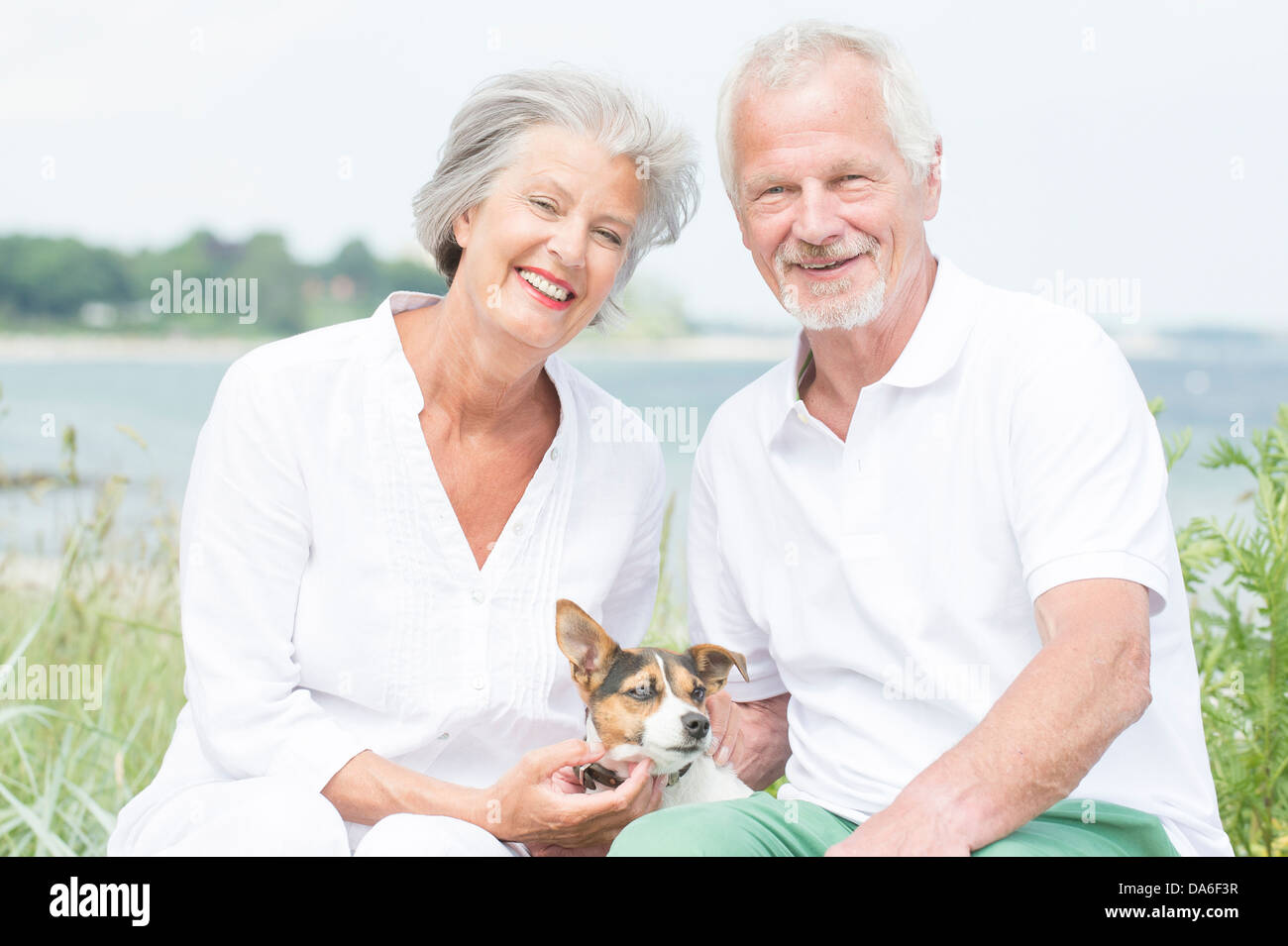 Lächelnd und Strategieberatung senior paar mit Hund Stockfoto