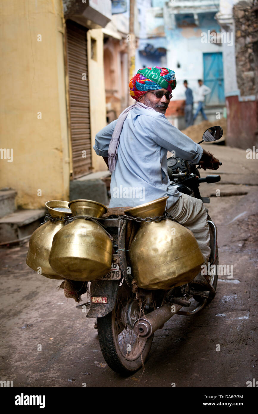 Milchmann Motorradfahren mit Milchbehälter Stockfoto