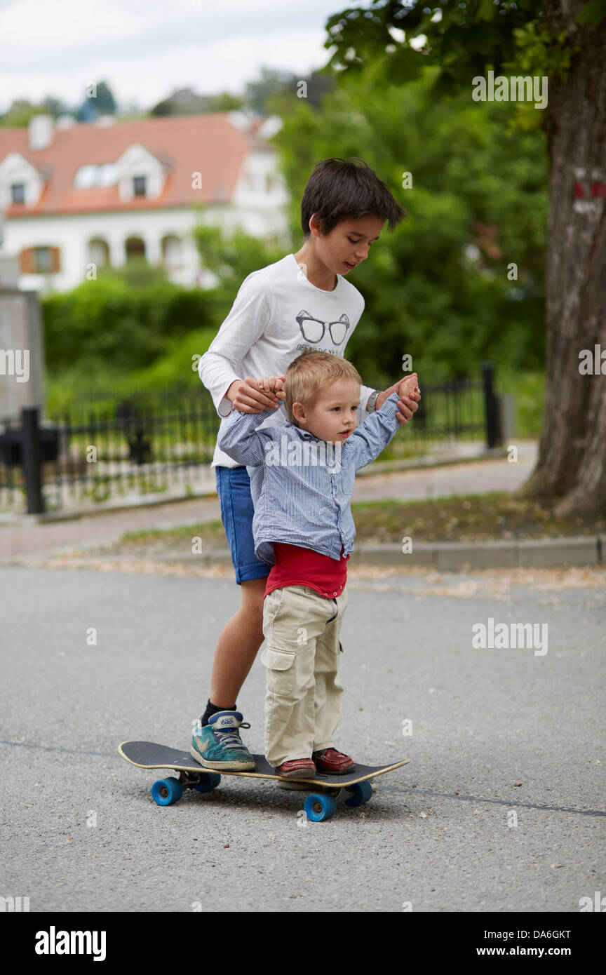 Ältere und jüngere Brüder Reiten eine skateboard Stockfoto