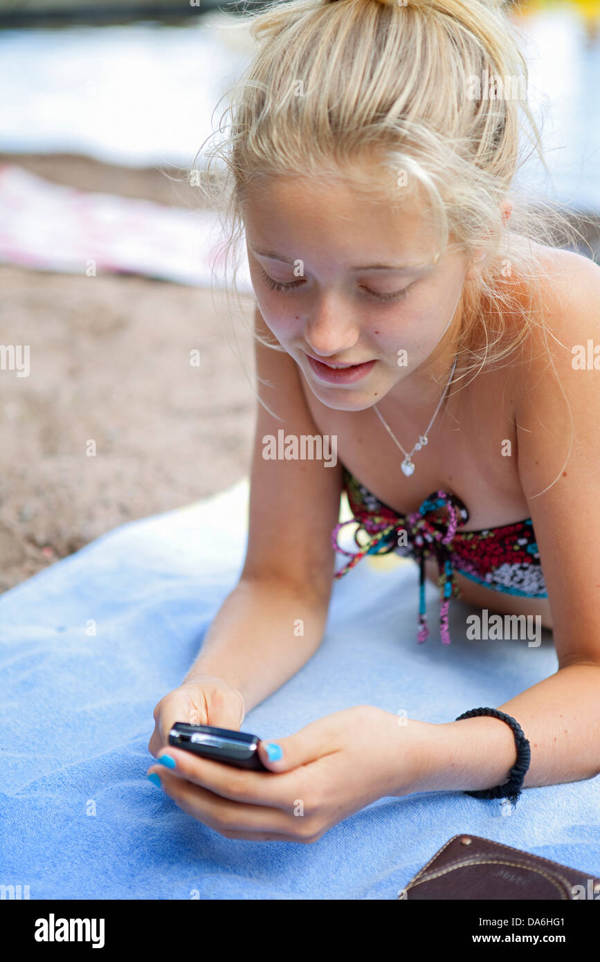 Teenager Mädchen 14 15 Liegen Am Strand Und Text Messaging 