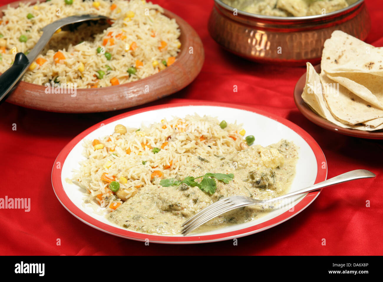 Selbstgemacht, Indisch-Stil Abendessen Fisch in grüner Curry-Sauce serviert mit dreifarbigen Gemüse Pilau Reis und Chappatis. Stockfoto