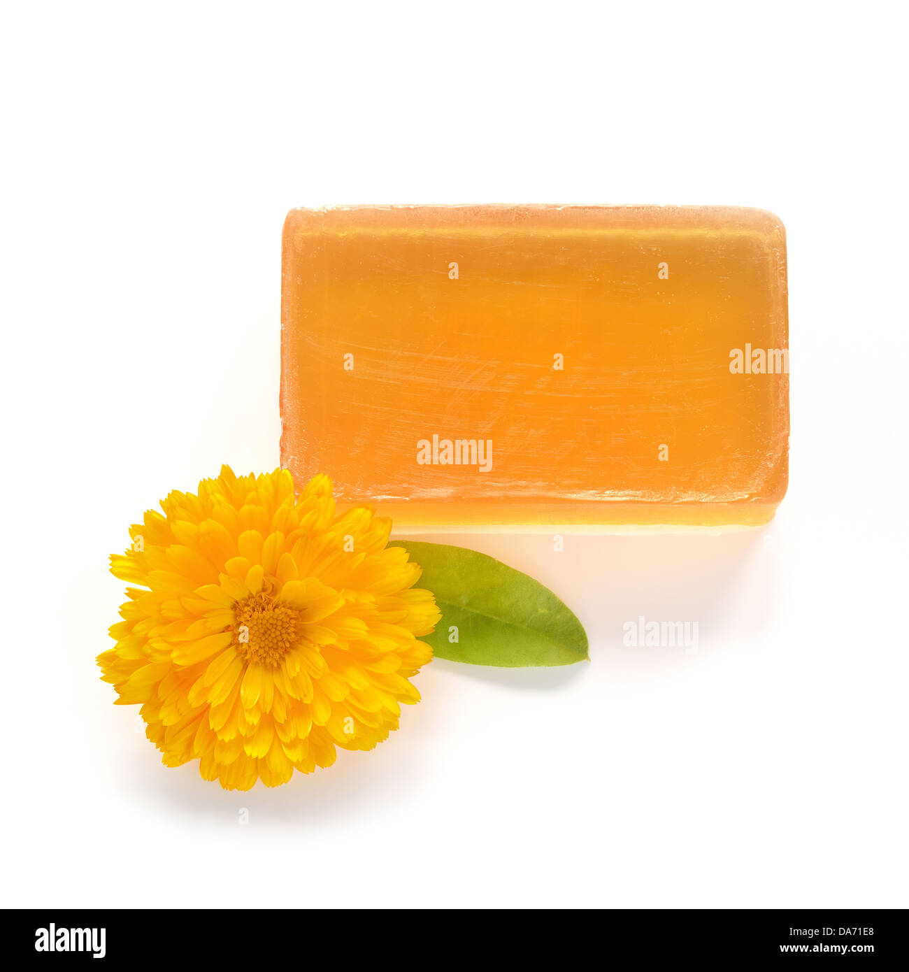 Orange handgefertigten Glycerin Seife und Ringelblume Blüten auf weißem Hintergrund. Hypoallergene Seife mit Ringelblumen-Extrakt. Schönheitspflege. Stockfoto