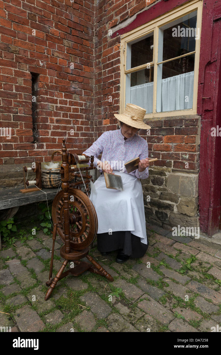 Shropshire. Acton Scott Historic working Farm. Viktorianische kostümierte Frau Hand kardierte wolle. England, Großbritannien Stockfoto