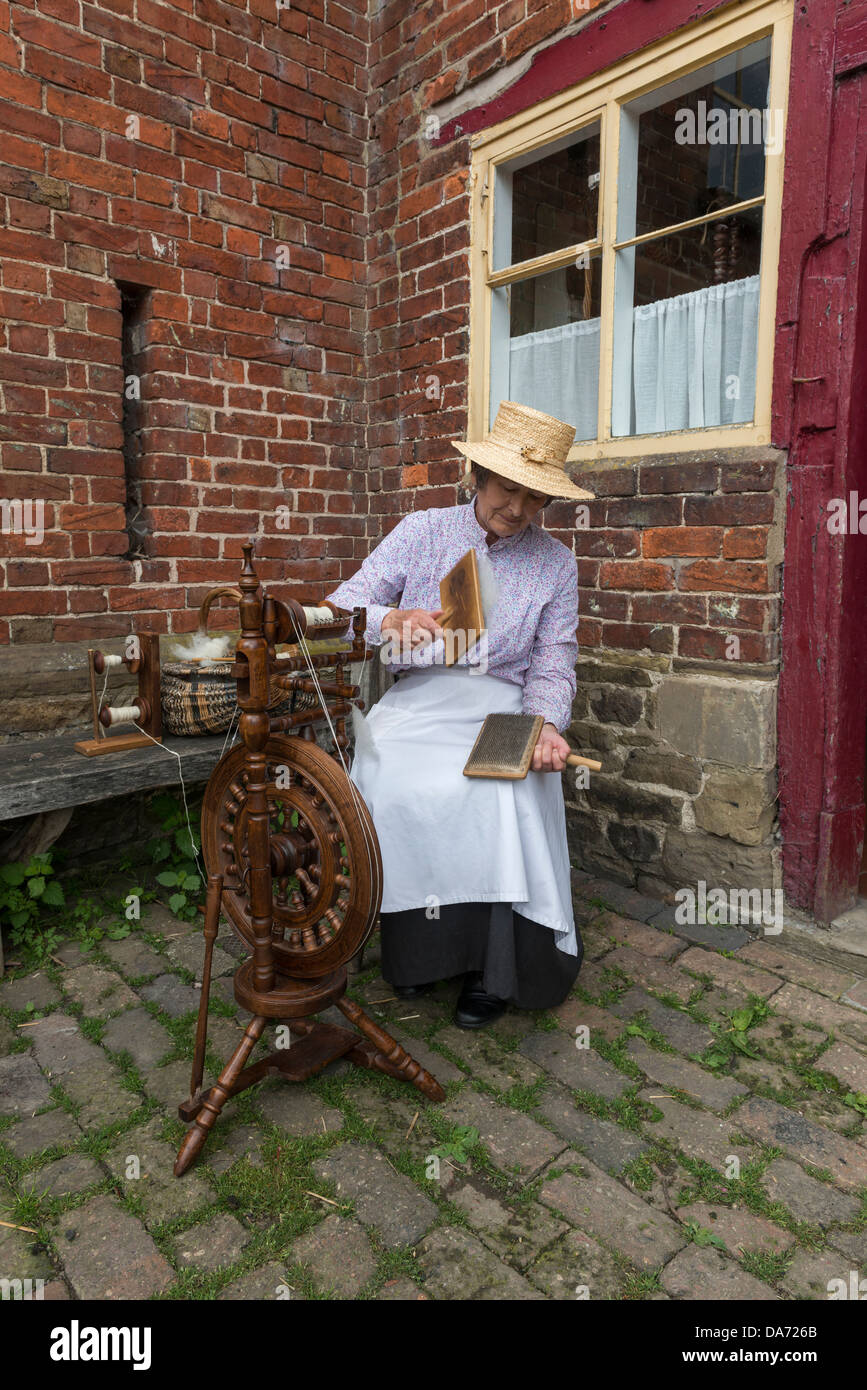 Shropshire. Acton Scott Historic working Farm. Viktorianische kostümierte Frau Hand kardierte wolle. England, Großbritannien Stockfoto