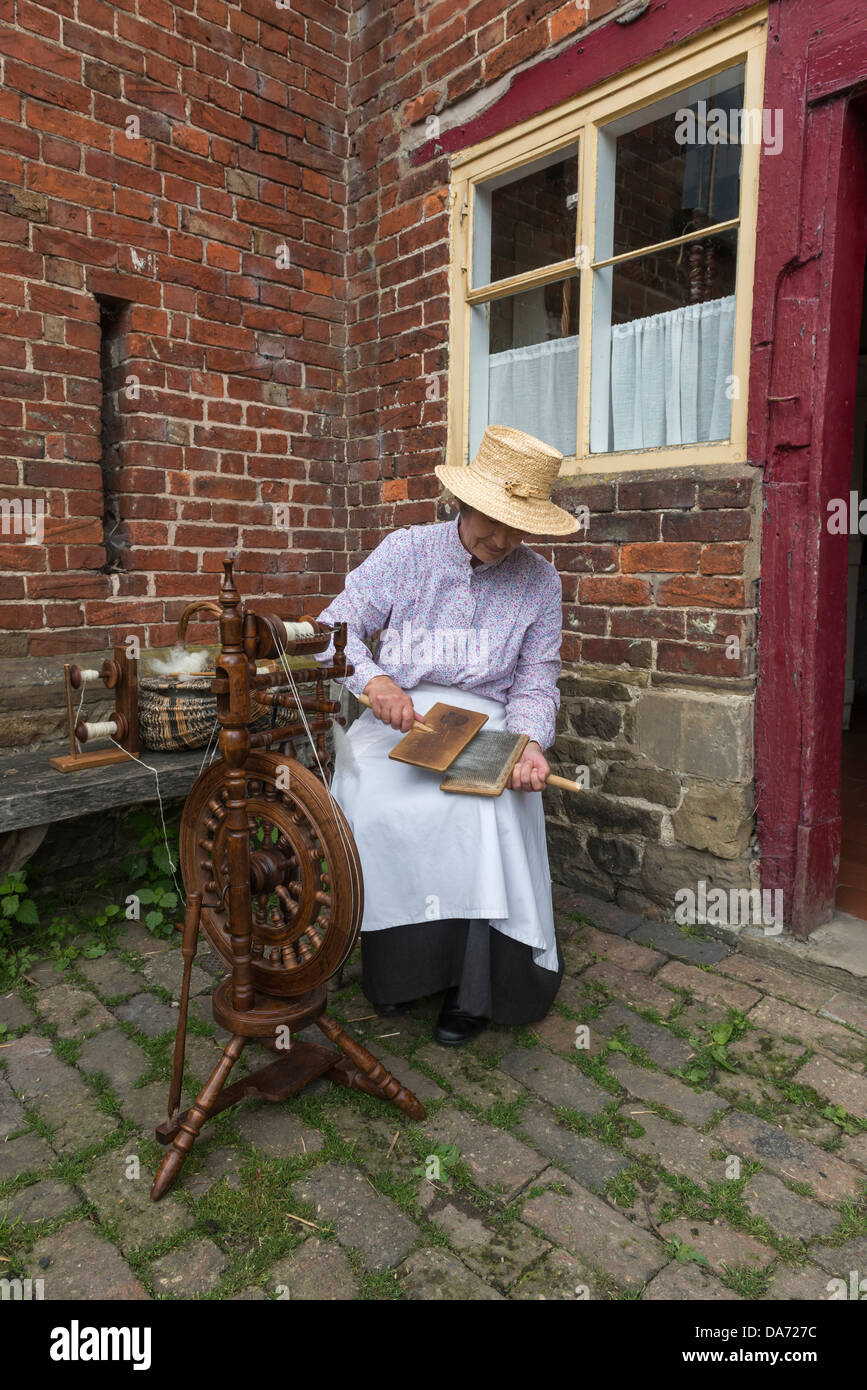 Shropshire. Acton Scott Historic working Farm. Viktorianische kostümierte Frau Hand kardierte wolle. England, Großbritannien Stockfoto