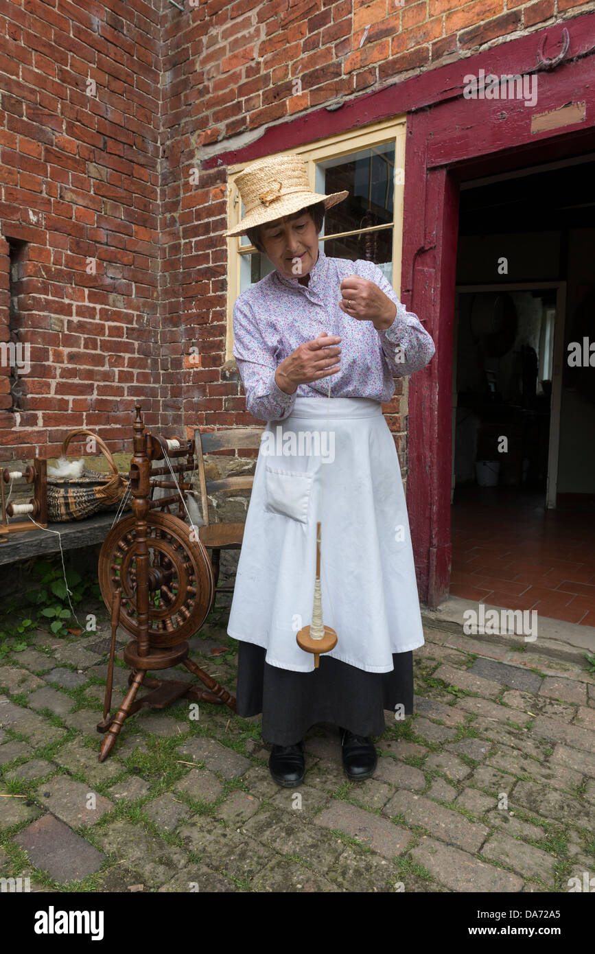 Shropshire. Acton Scott Historic working Farm. Viktorianische kostümierte Frau Spinnen auf einer Hand Spindel. England, Großbritannien Stockfoto
