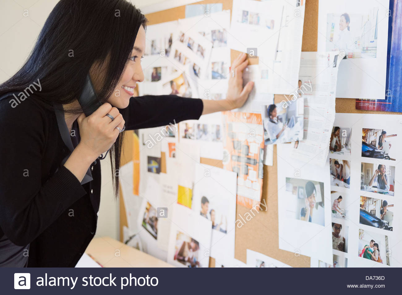 Geschäftsfrau sucht am schwarzen Brett im Büro Stockfoto