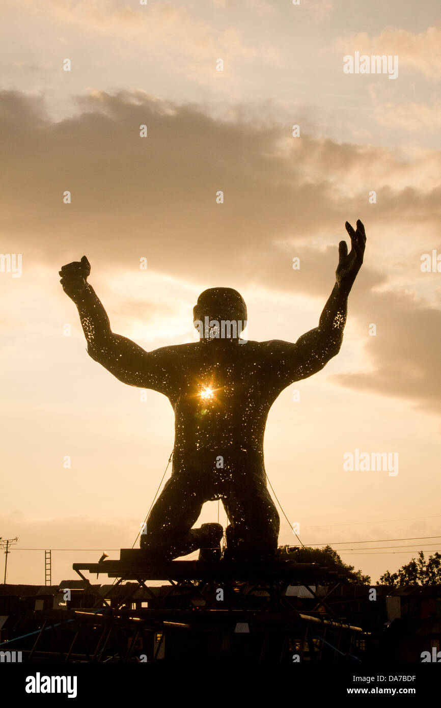 Statue von einem riesigen Mann auf die Knie in der Arena Silber Hayes, Glastonbury Festival 2013 Stockfoto