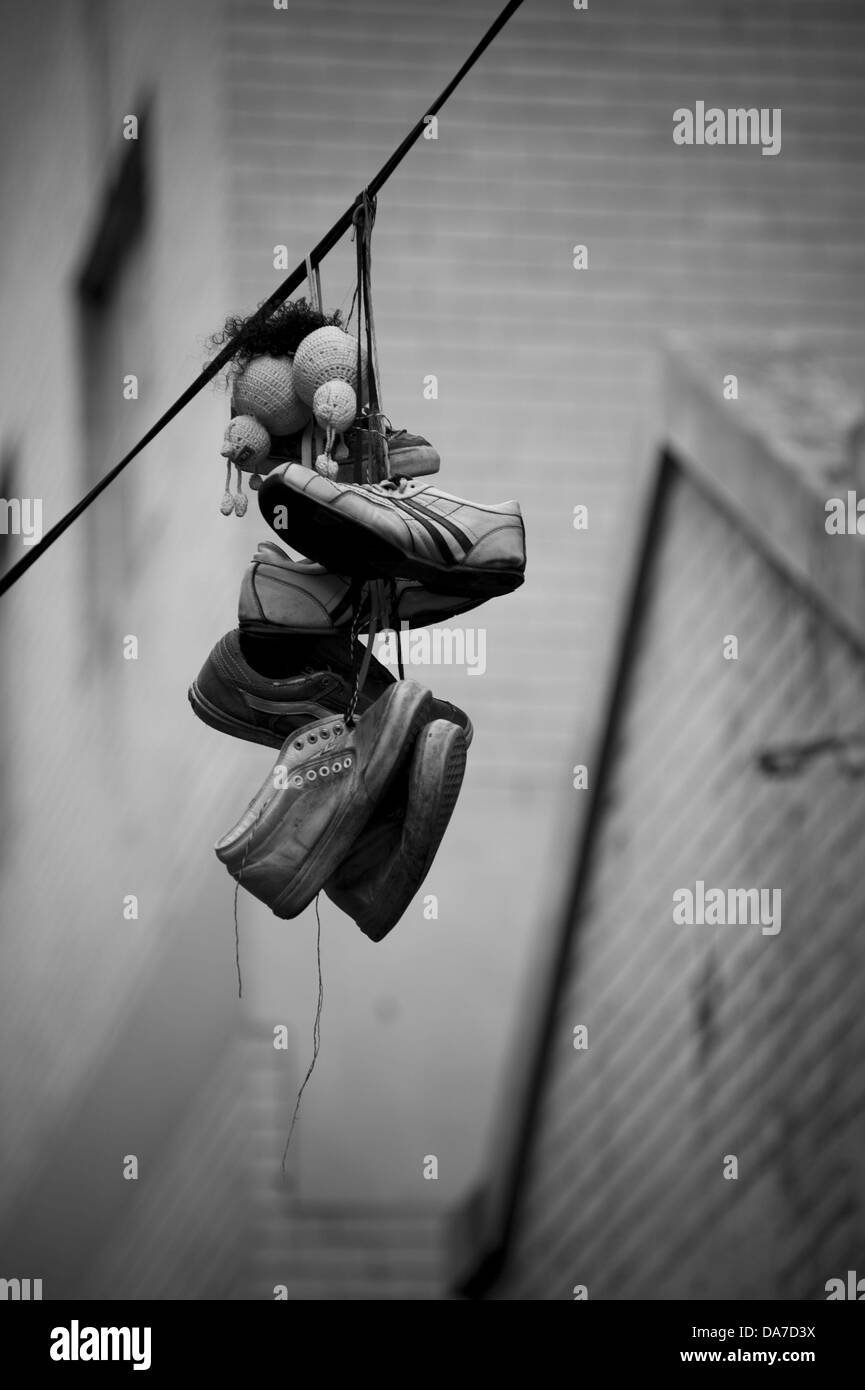 Turnschuhe, hängen von der Schnürsenkel über powerlines Stockfoto