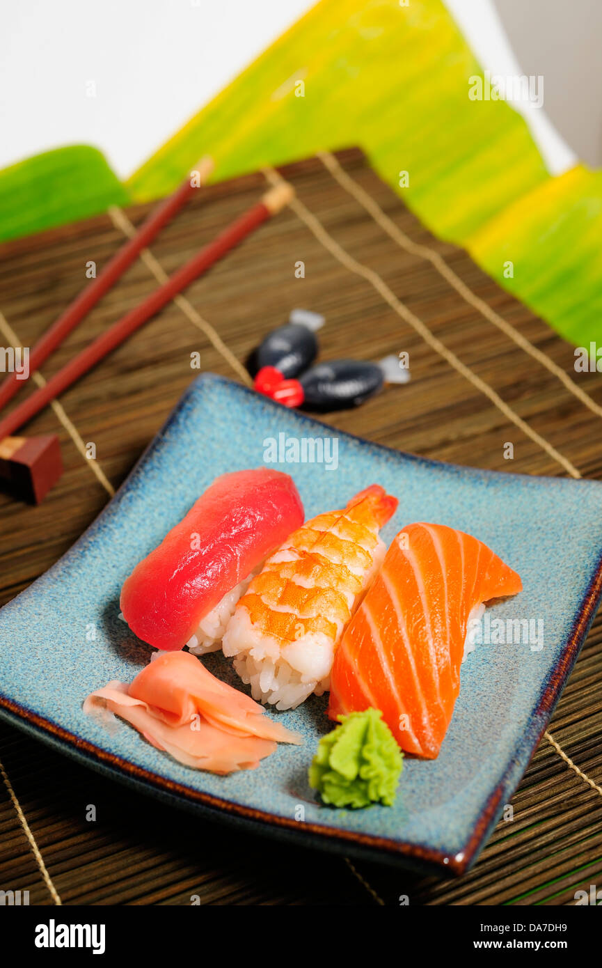 Gemischte Sushi Platte, Garnele, Lachs und Thunfisch mit Ingwer und Wasabi auf Bambus Matte Stockfoto