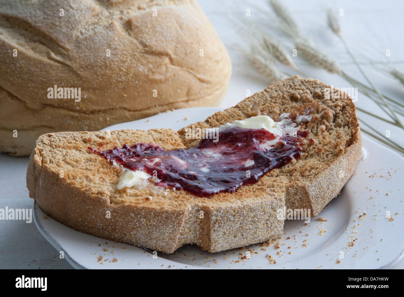 Scheibe Brot mit Butter und Erdbeermarmelade Stockfoto