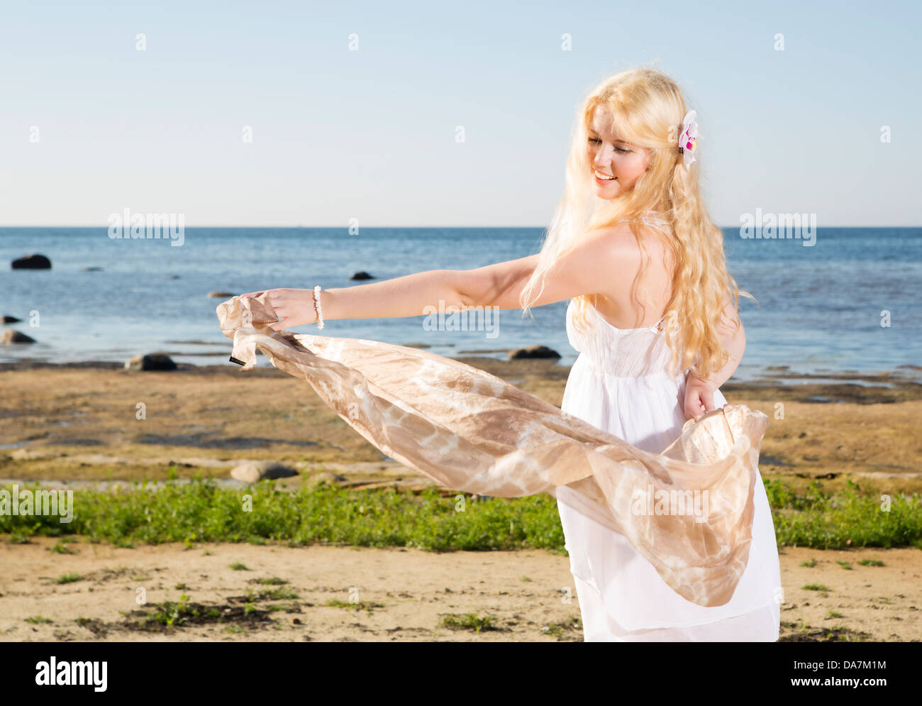 Junge Frau mit leichten Schal am Strand spielen Stockfoto