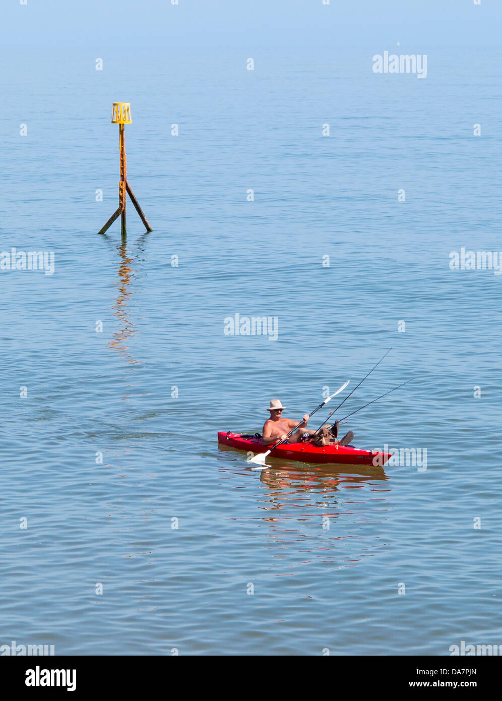 Mann Angeln vom Kanu in Sidmouth, Devon, England Stockfoto