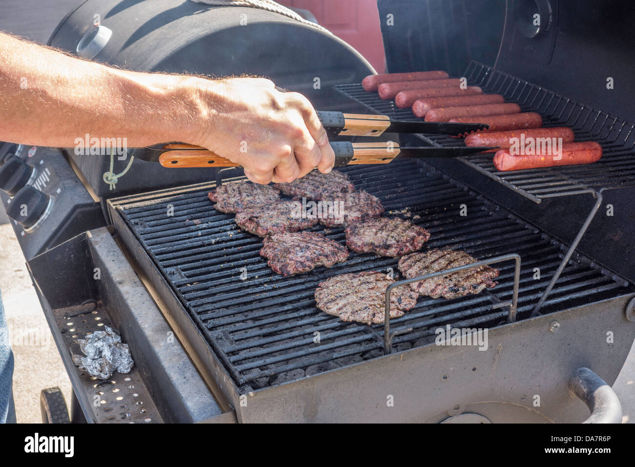 Hamburger und Hot Dogs auf einem Holzkohlegrill im freien kochen. USA. Stockfoto