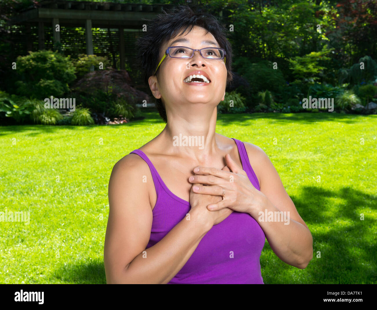 Eine asiatische Frau hat einen Moment der Erleuchtung in ihrem Garten Stockfoto