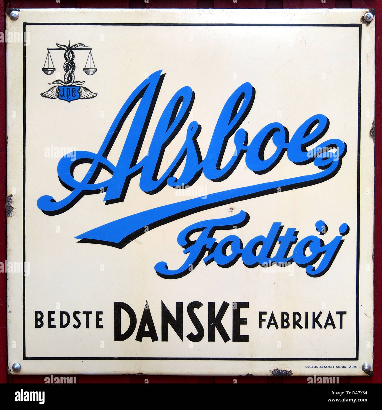 Dieses Vintage dänische Emaille-Werbezeichen wirbt für Alsboe Fodtoj, ein Unternehmen, das für seine Schuhe bekannt ist. Das Schild spiegelt den Werbestil des frühen 20. Jahrhunderts wider und kombiniert lebendige Farben mit traditionellem dänischem Design. Es ist ein seltenes Stück Marketinggeschichte, das die Handwerkskunst dänischer Schilderhersteller und die Kultur der Werbung in Dänemark zeigt. Stockfoto