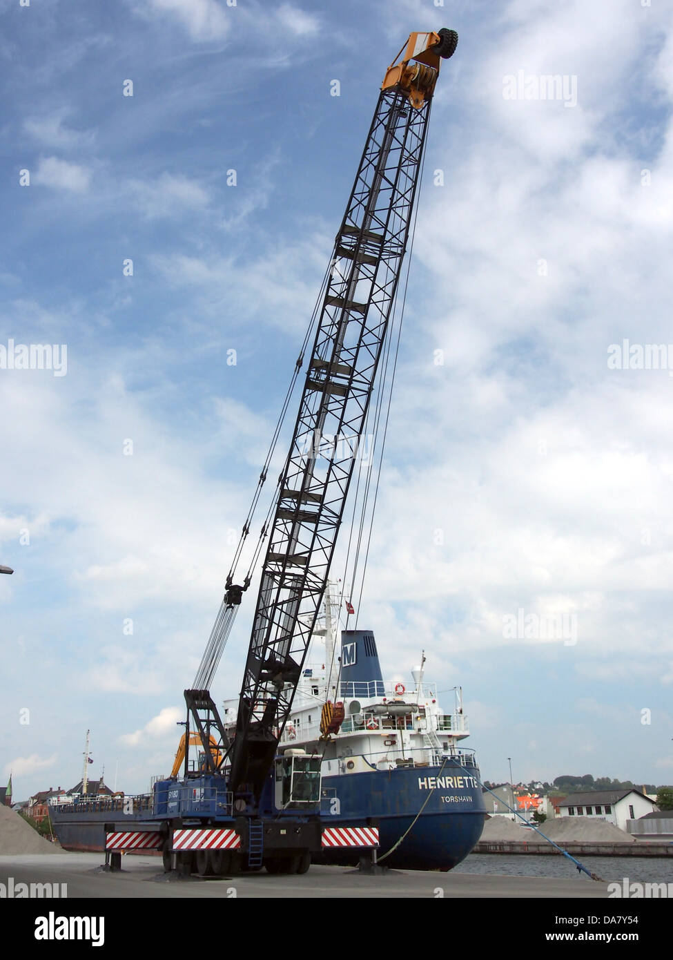 Der Hafenkran Sennebogen 6180 ist im Vejle Harbor abgebildet und zeigt seine Fähigkeiten beim Heben und Transportieren schwerer Güter. Als Teil des modernen Hafenbetriebs steht dieser Kran für Effizienz und Präzision in der Hafenlogistik und spielt eine entscheidende Rolle im Seehandel und im Frachtumschlag. Stockfoto