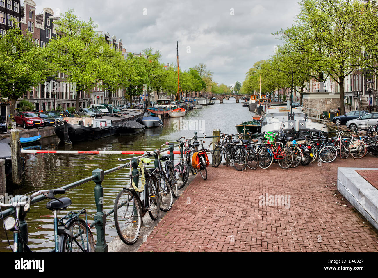 Fahrräder und Boote auf dem Kanal in Amsterdam, Niederlande, Provinz Nordholland. Stockfoto