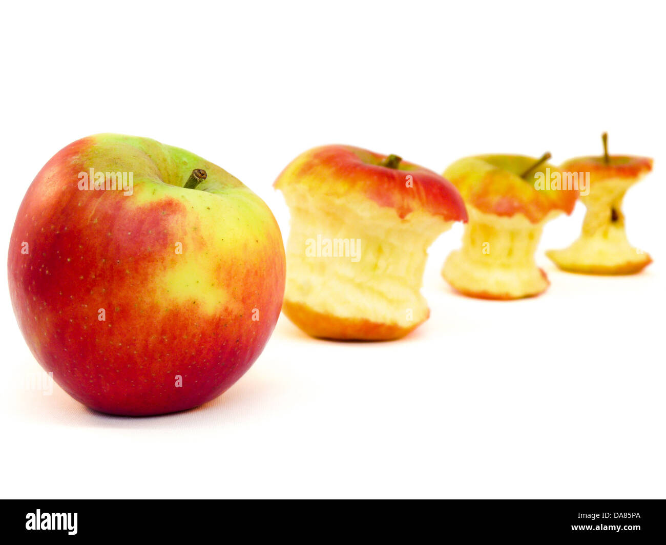 Vier Äpfel und Apfel Kerne liegen schräg auf einem weißen Hintergrund Stockfoto