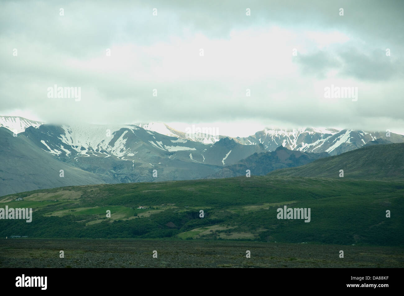 Ein Blick vom isländischen tiefliegende Südküste der krasser schneebedeckten bergigen Landesinneren Stockfoto