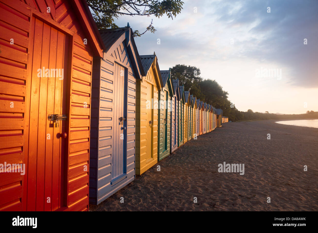 Bunt bunt bemalten Strandhütten im Morgengrauen / Sonnenaufgang Llanbedrog Strand Llyn Halbinsel Gwynedd North Wales UK Stockfoto