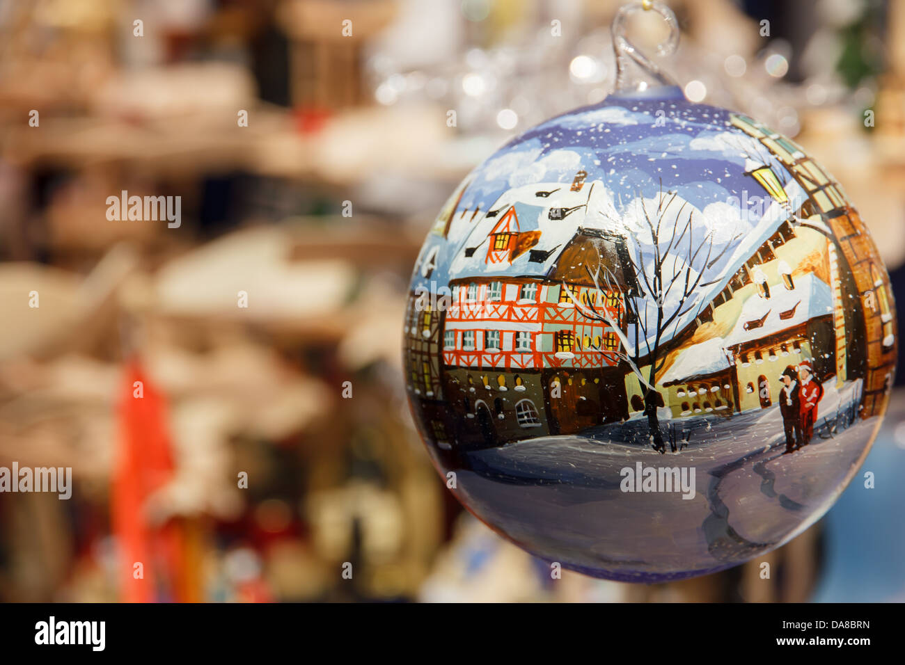 Christmas Ornament auf einem Weihnachtsmarkt gemalt mit einer Winterszene von einem deutschen Dorf Stockfoto