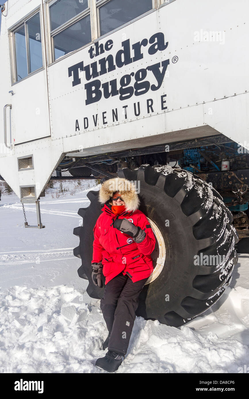 Besucher steht eines der riesigen Reifen von Tundra Buggys verwendet, um durch die Tundra für Sightseeing in der Nähe von Churchill, MB Reisen Stockfoto