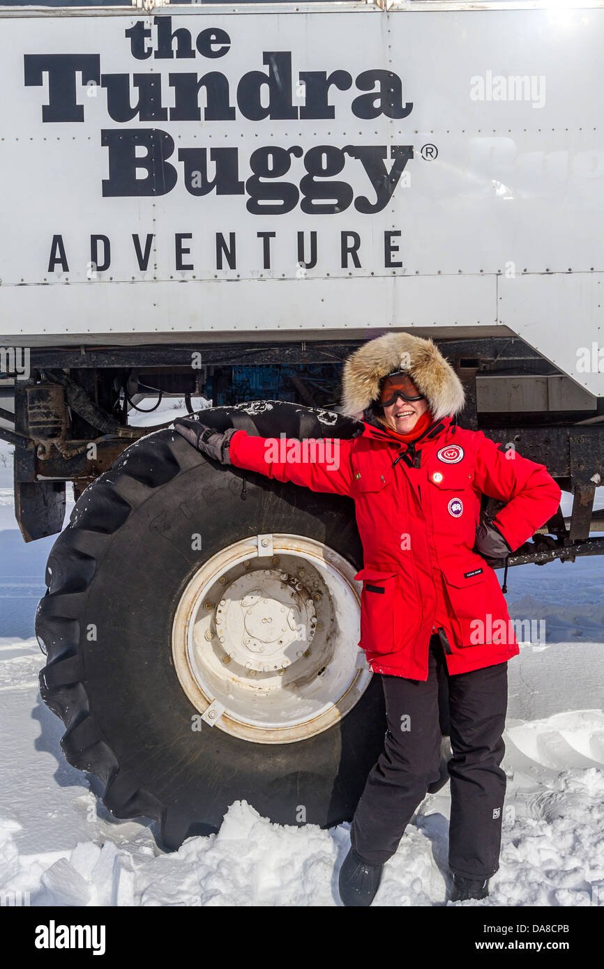 Besucher steht eines der riesigen Reifen von Tundra Buggys verwendet, um durch die Tundra für Sightseeing in der Nähe von Churchill, MB Reisen Stockfoto