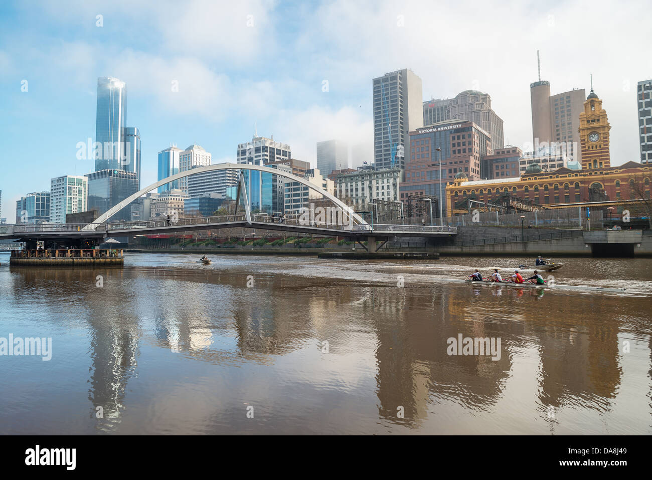 Ruderer auf den Yarra River und die Skyline der Innenstadt von Melbourne, Australien. Stockfoto