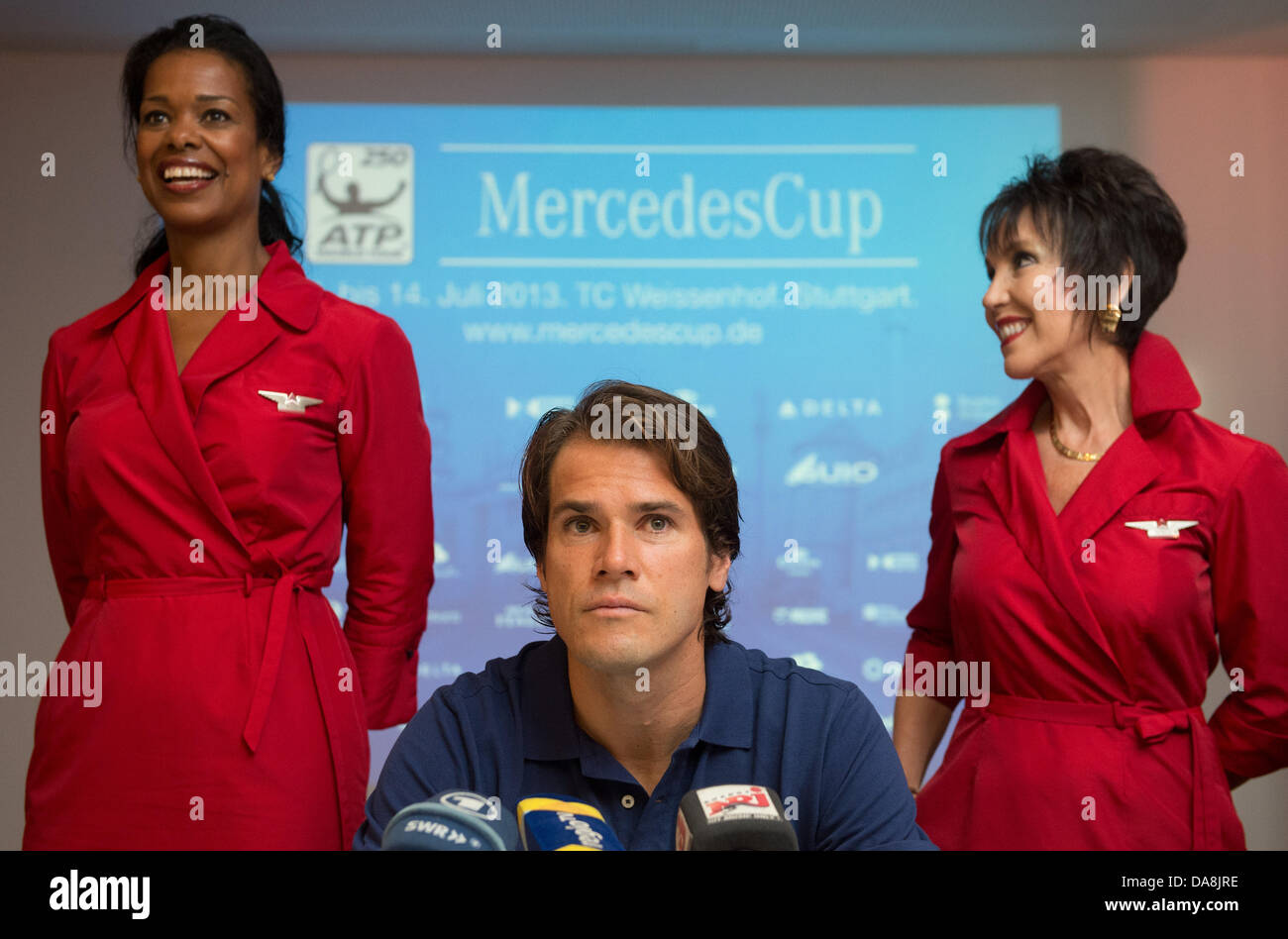 Deutscher Tennisspieler Tommy Haas sitzt an einer Pressekonferenz dazwischen zwei Frauen in Uniformen der Delta Air Lines, einer der Sponsoren des internationalen Tennis-Turnier in Stuttgart, Deutschland, 8. Juli 2013. Am 11. Juli 2013 dient Haas in der Runde der letzten 16 des ATP-Turniers in Stuttgart-Weißenhof in Stuttgart, Deutschland, 8. Juli 2013. Foto: MARIJAN MURAT Stockfoto