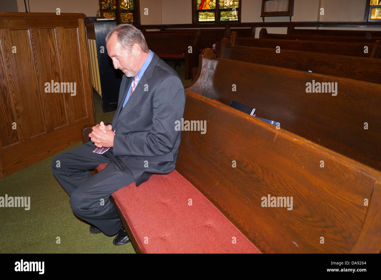 Reifer Mann in der Kirchenbank in der Kirche zu beten. Stockfoto