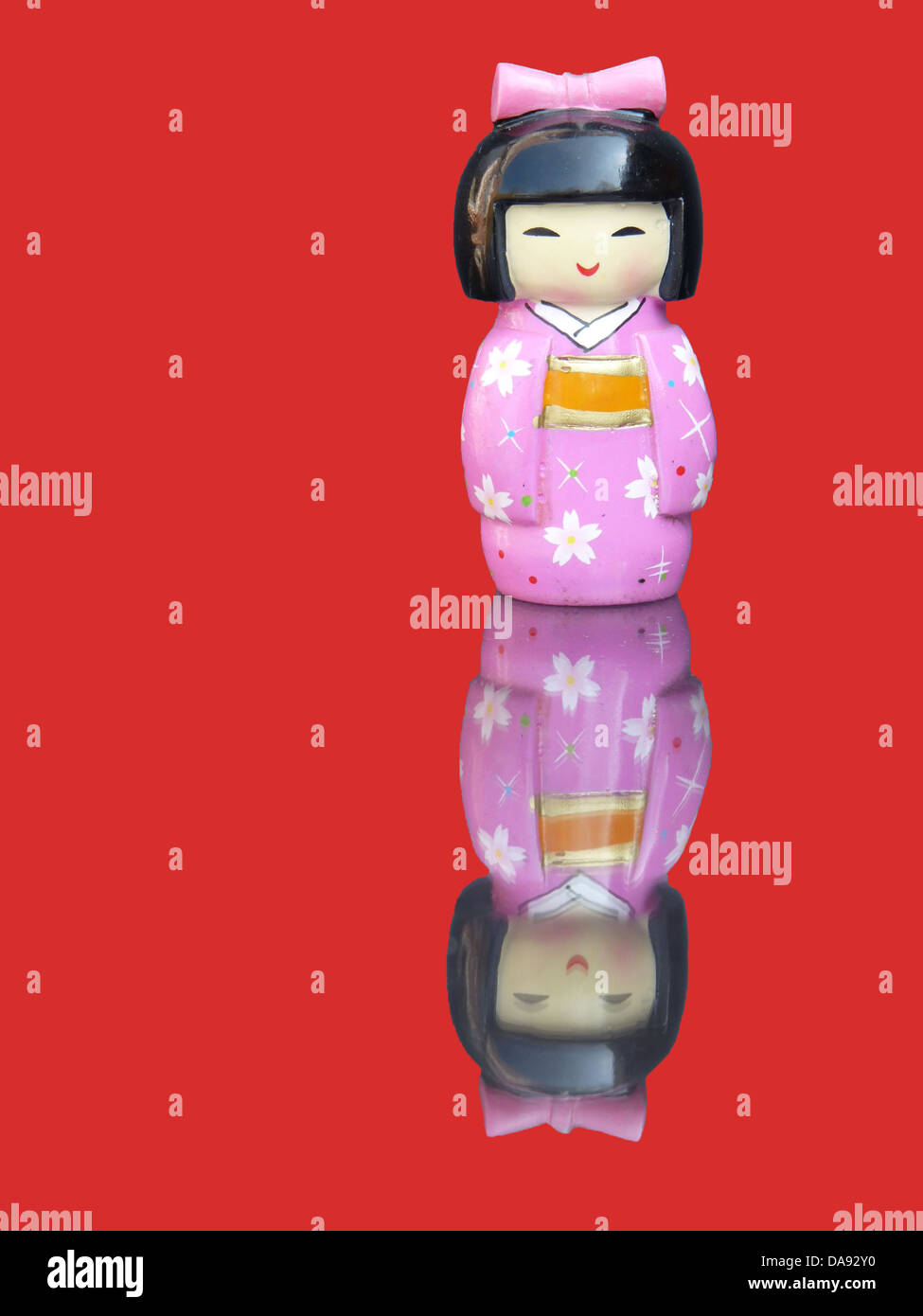 Chinesischen Porzellanfigur in einem rosa Kleid mit einem Spiegelbild auf einem roten Hintergrund isoliert Stockfoto