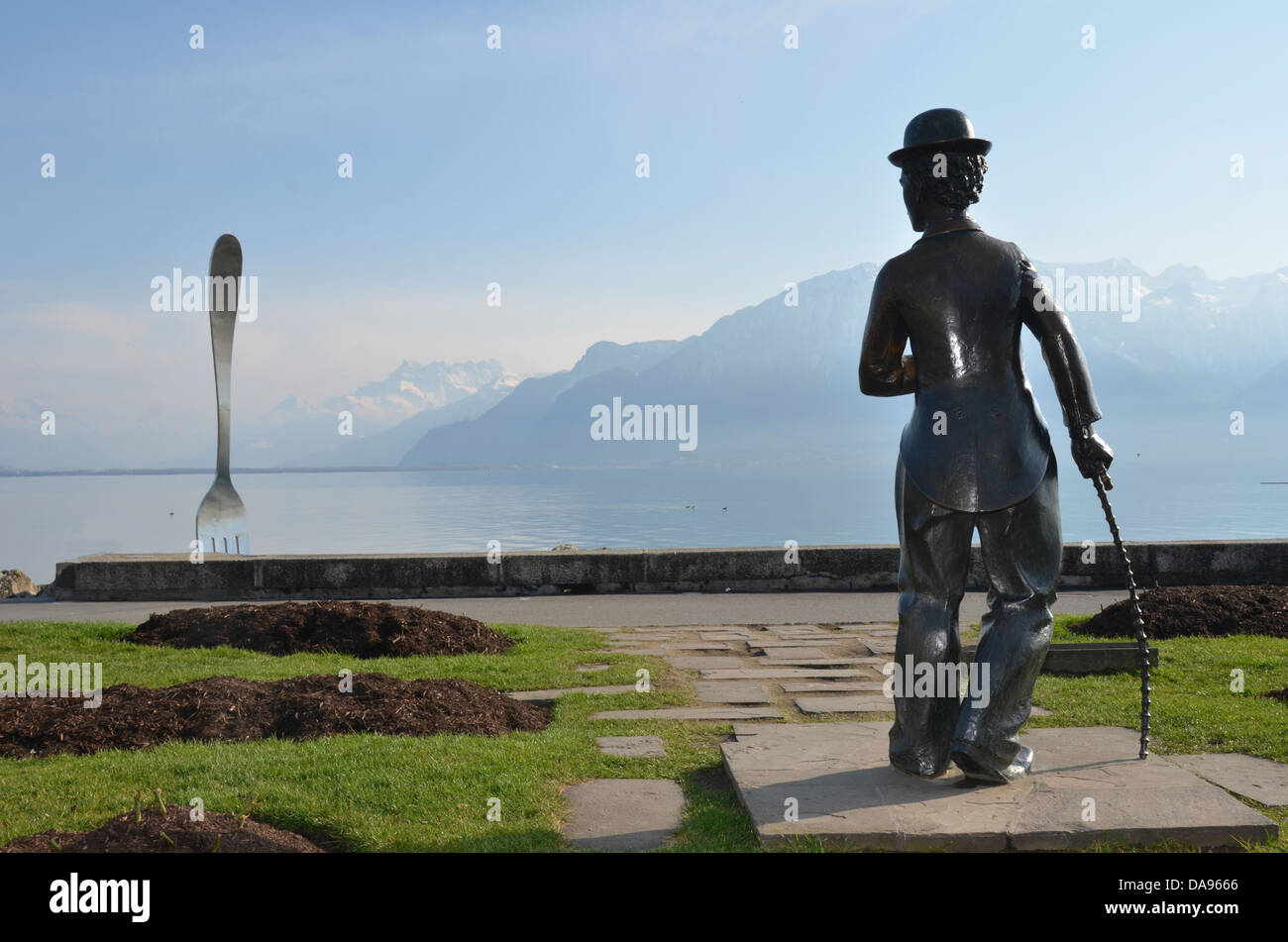eine Bronzestatue von Charlie Chaplin starrt auf die riesige Gabel in den Genfersee in Vevey, wo er lebte und starb Stockfoto