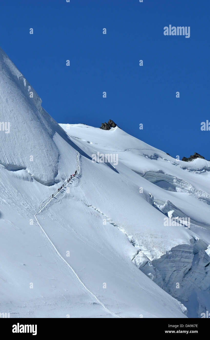 Team von nicht identifizierten, steilen Hang, Seilschaft über eine riesige Gletscherspalte, in einwandfreiem Zustand unter blauem Himmel Stockfoto