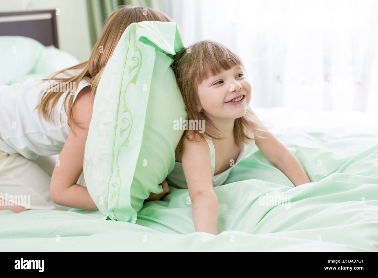 zwei Mädchen spielen im Bett Stockfoto