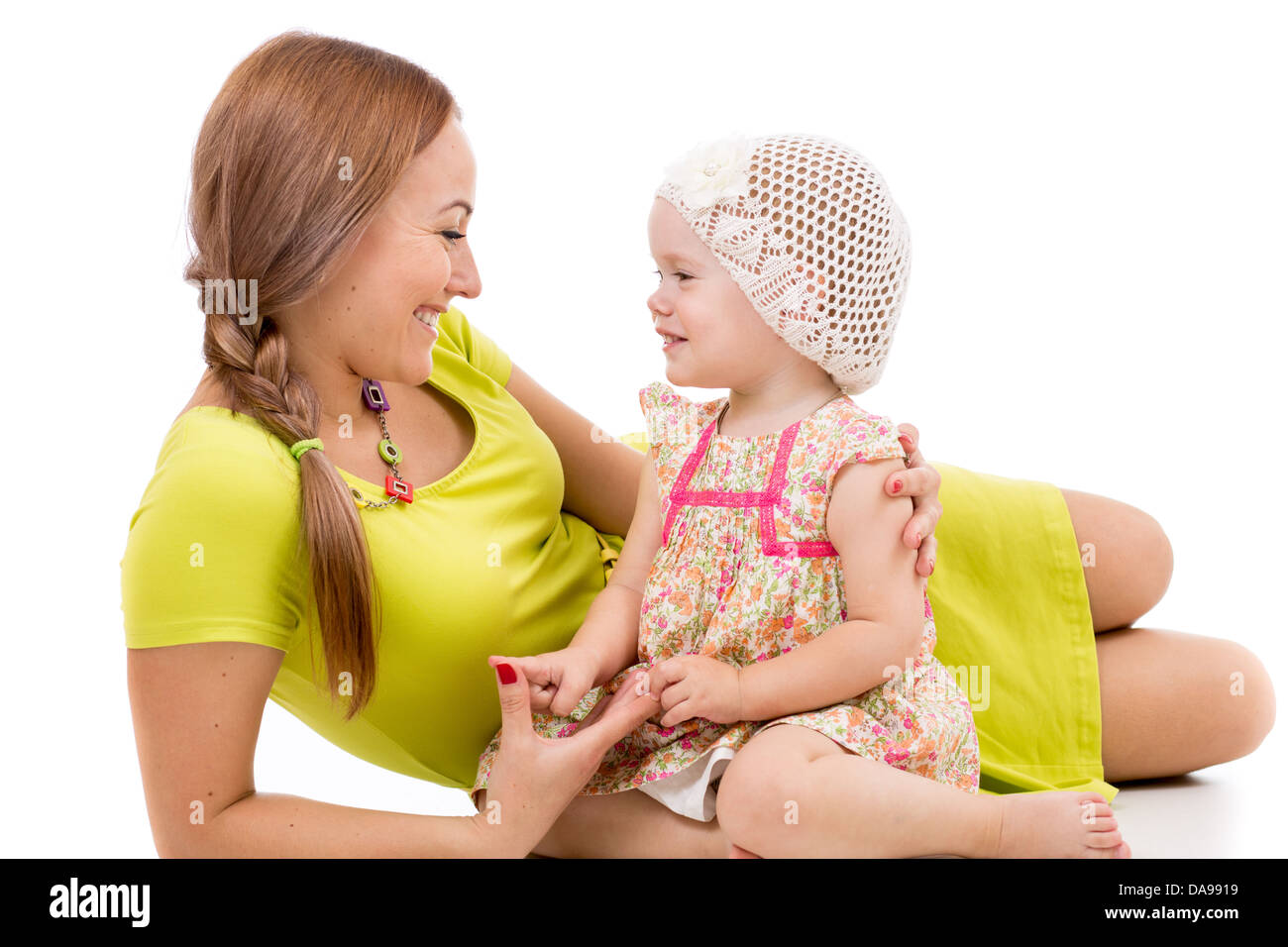 glückliche Mutter und Mädchen auf weißem Boden liegend und lächelnd Stockfoto