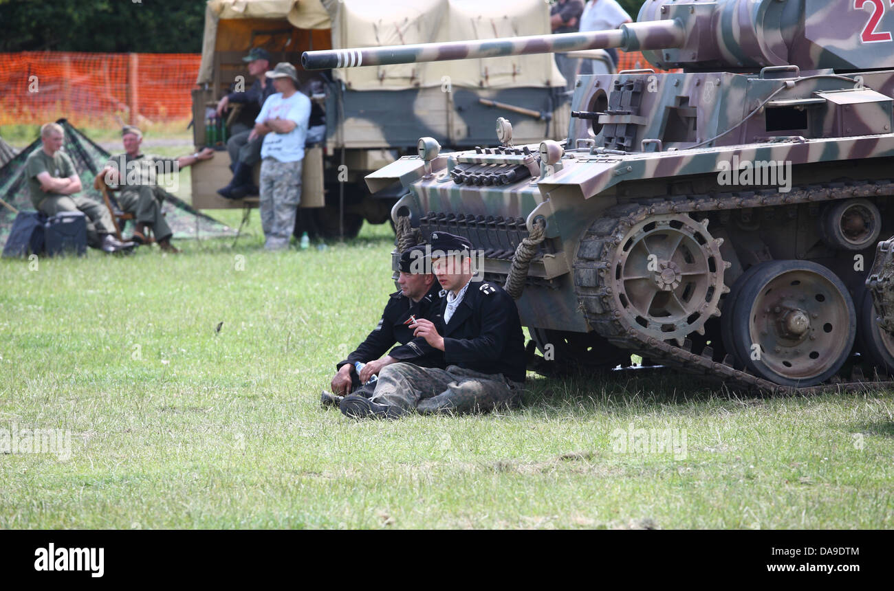 Crew-Mitglieder, die von einem Panzer 3 Tank während WW2 re Enactment Schlacht entspannend Stockfoto