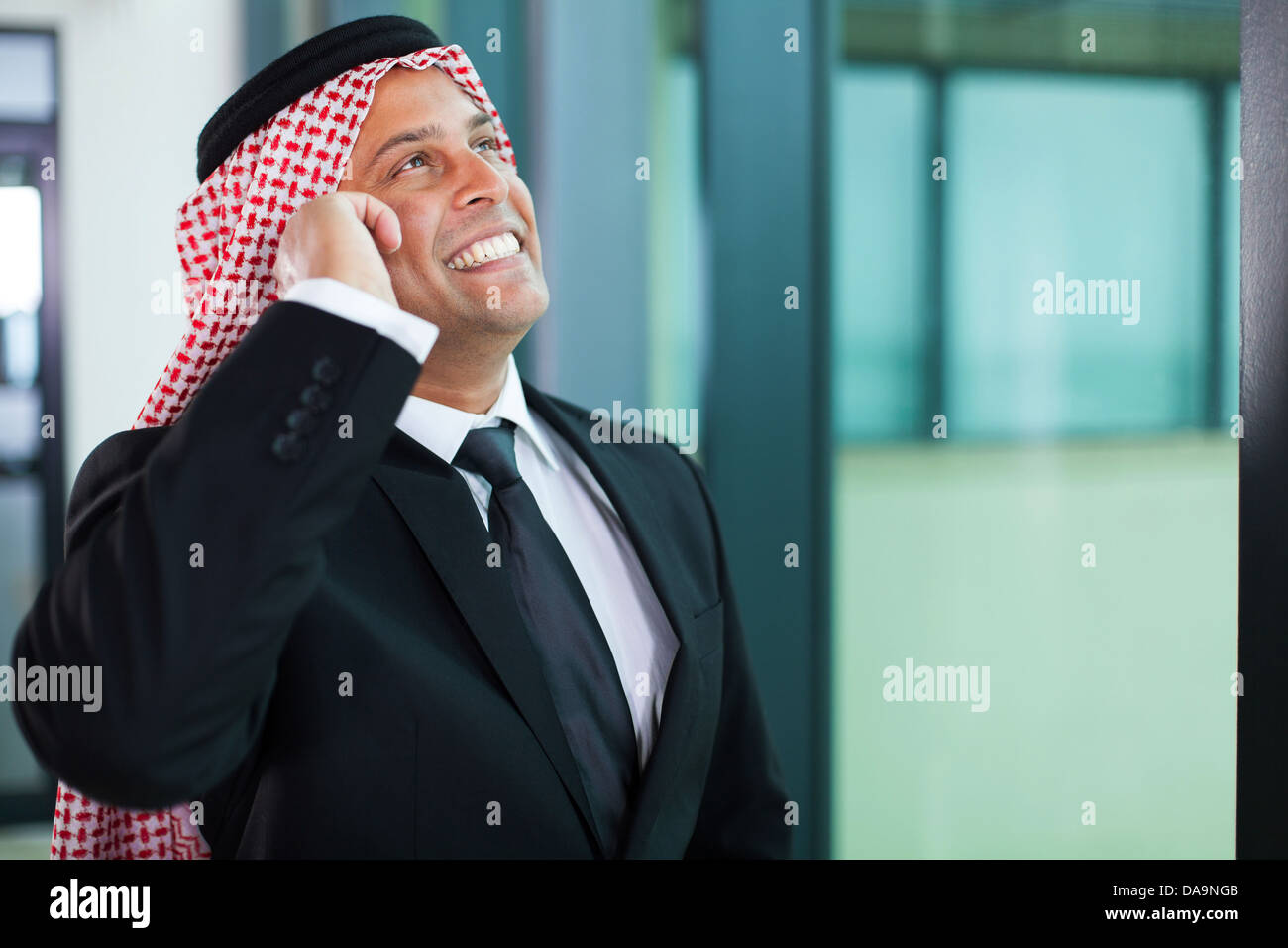 fröhliche muslimischen Geschäftsmann reden über Handy und nachschlagen Stockfoto