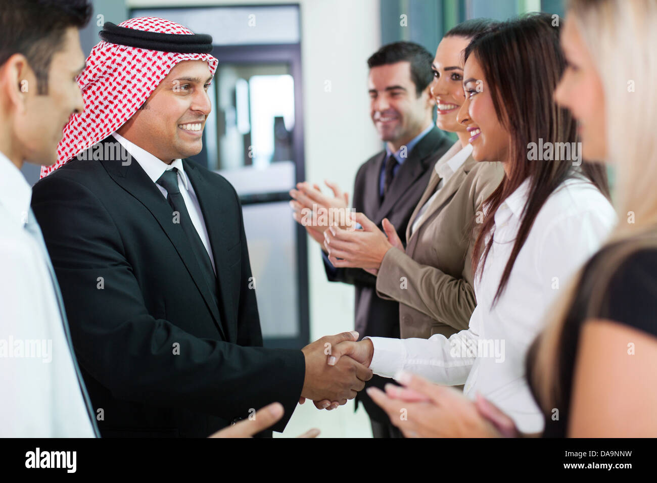 fröhliche Gruppe von Business Team einladende arabischen Geschäftsmann Stockfoto