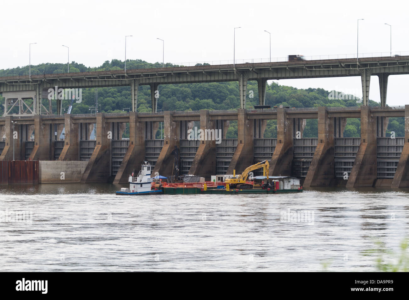 Ein Lastkahn betreibt unter dem Chickamauga Damm auf dem Tennessee River bei bewölktem Himmel Stockfoto