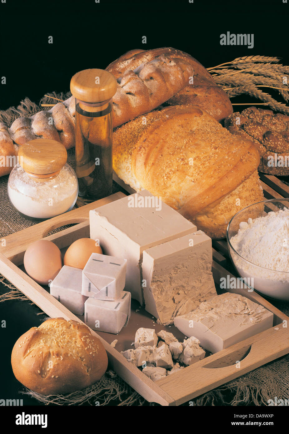 Stillleben mit Brot und Produkte für die Herstellung von Brot auf einem schwarzen Hintergrund Stockfoto