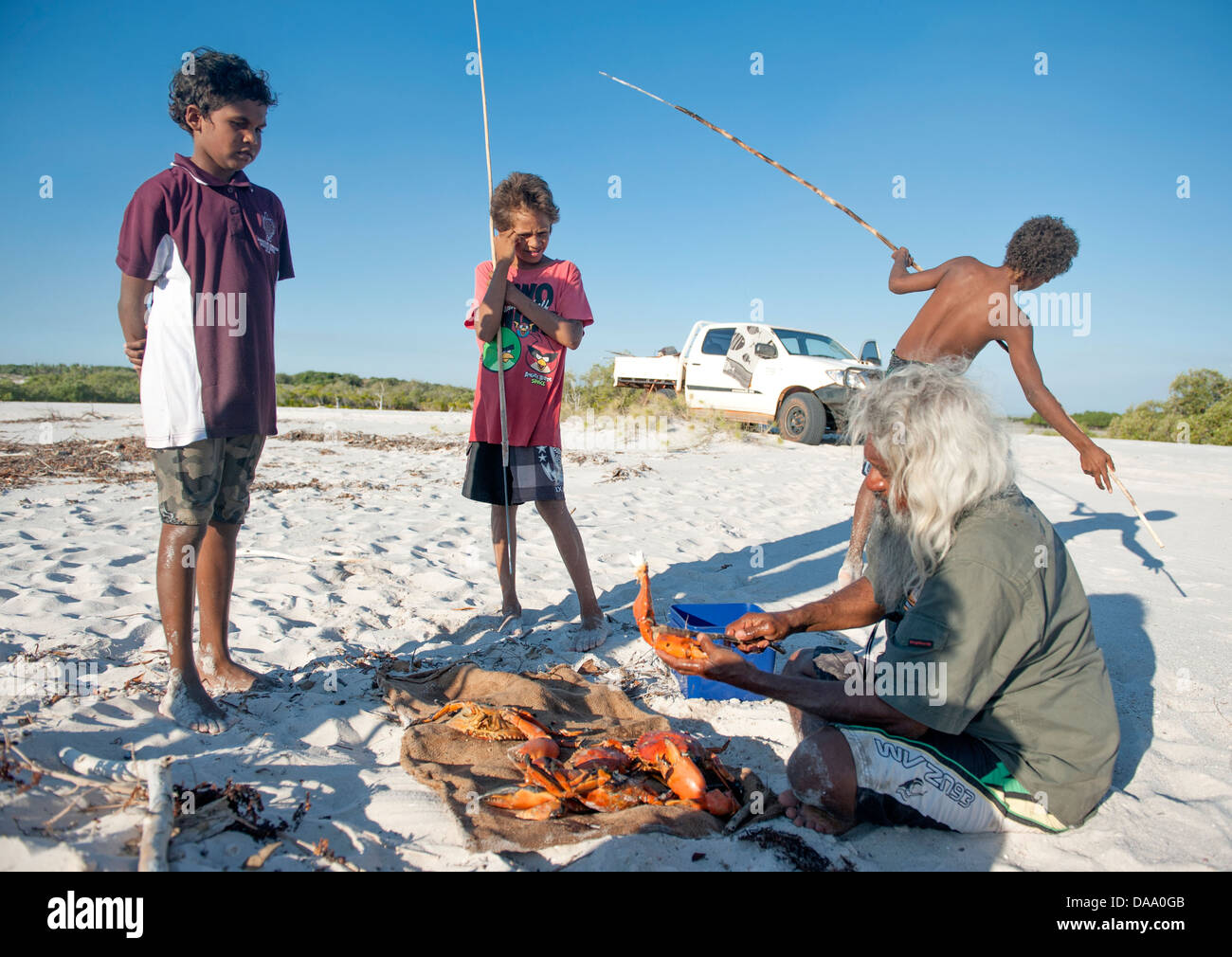 Aboriginal Guide Brian Lee und einheimischen jungen am Lagerfeuer im Hinterland von Cape Leveque Kochen Schlamm Krabben Stockfoto