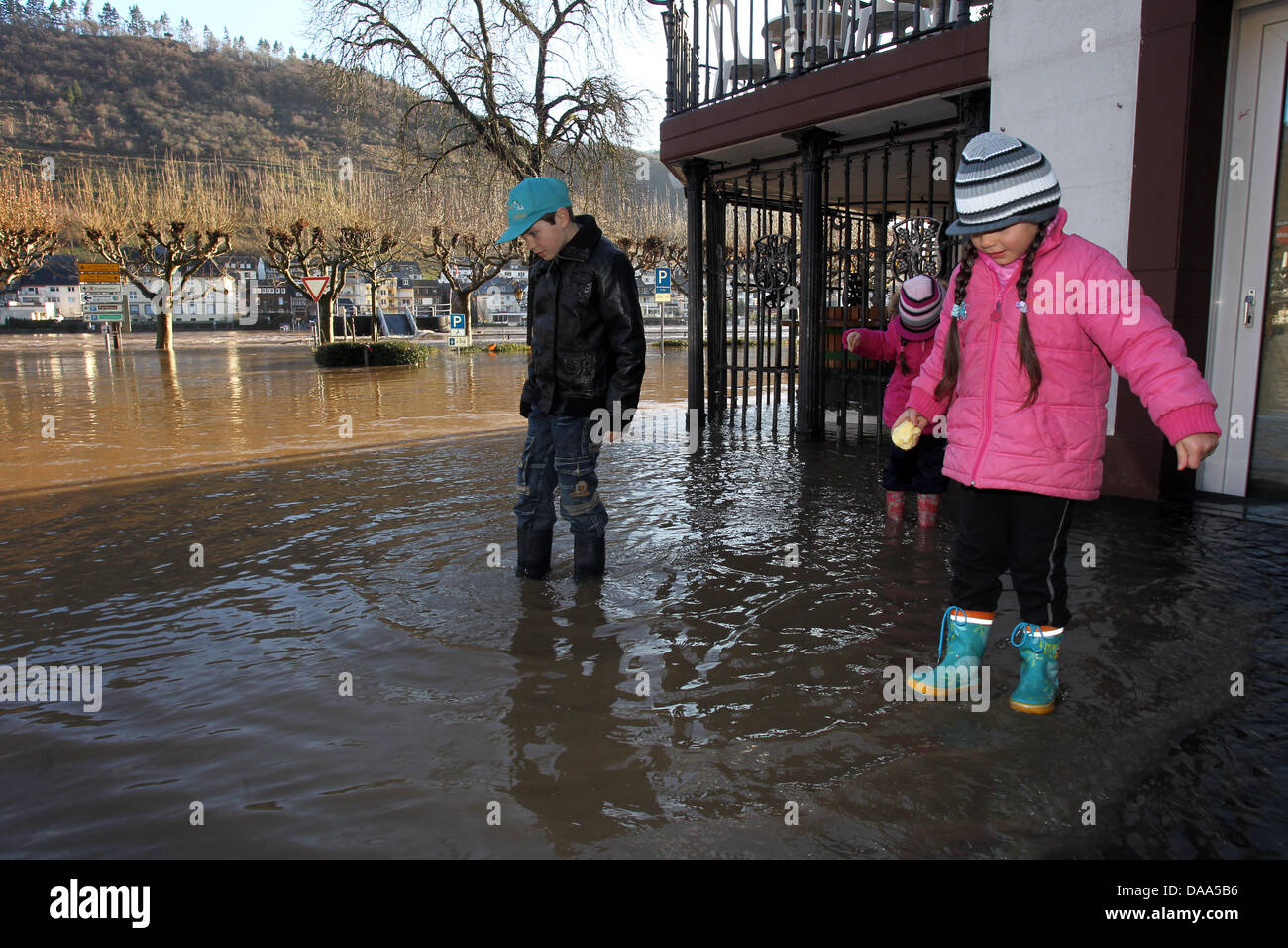 Kinder spielen auf einer überfluteten Straße in der alten Stadt Zentrum von Cochem, Deutschland, 8. Januar 2011. Die Stadt Cochem liegt am Ufer der Mosel. Aufgrund der wärmeren Temperaturen hat Tauwetter eingesetzt. Zusammen mit mehr Regen führen diese Wetterbedingungen zu Überschwemmungen in Deutschland, vor allem an Rhein und Mosel und ihre Nebenflüsse. Foto: Thomas Frey Stockfoto