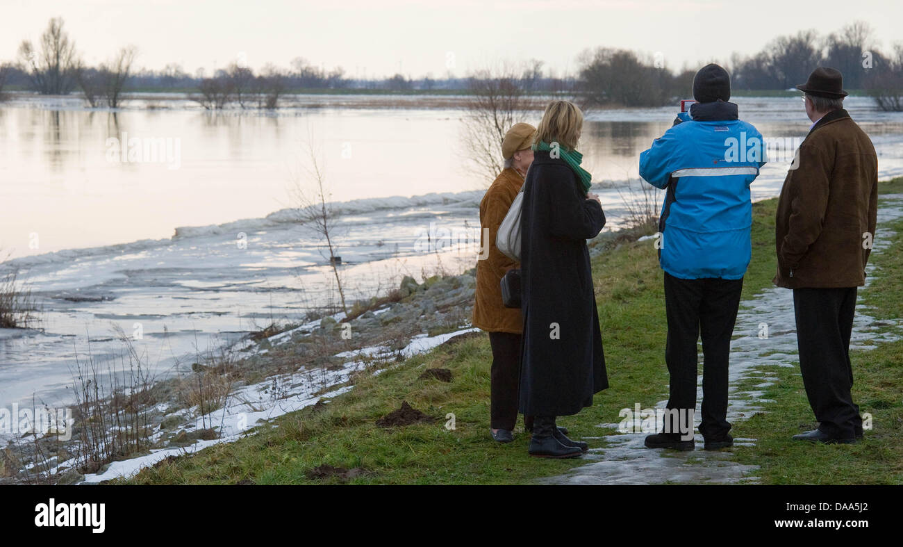 Schaulustige stehen auf dem Deich beobachten das Hochwasser in Hohenwutzen, Deutschland, 9. Januar 2011. Trotz Schnee, Eis und Eis schmelzen, sind die hohen Wasserstände am Fluss Oder stabil. Auf Teile des Flusses der höchsten Flut Alarm ist in der Tat, aber die Eisschollen haben von Eisbrechern verschoben worden und der Wasserstand ist langsam zurückgeht. Foto: PATRICK PLEUL Stockfoto